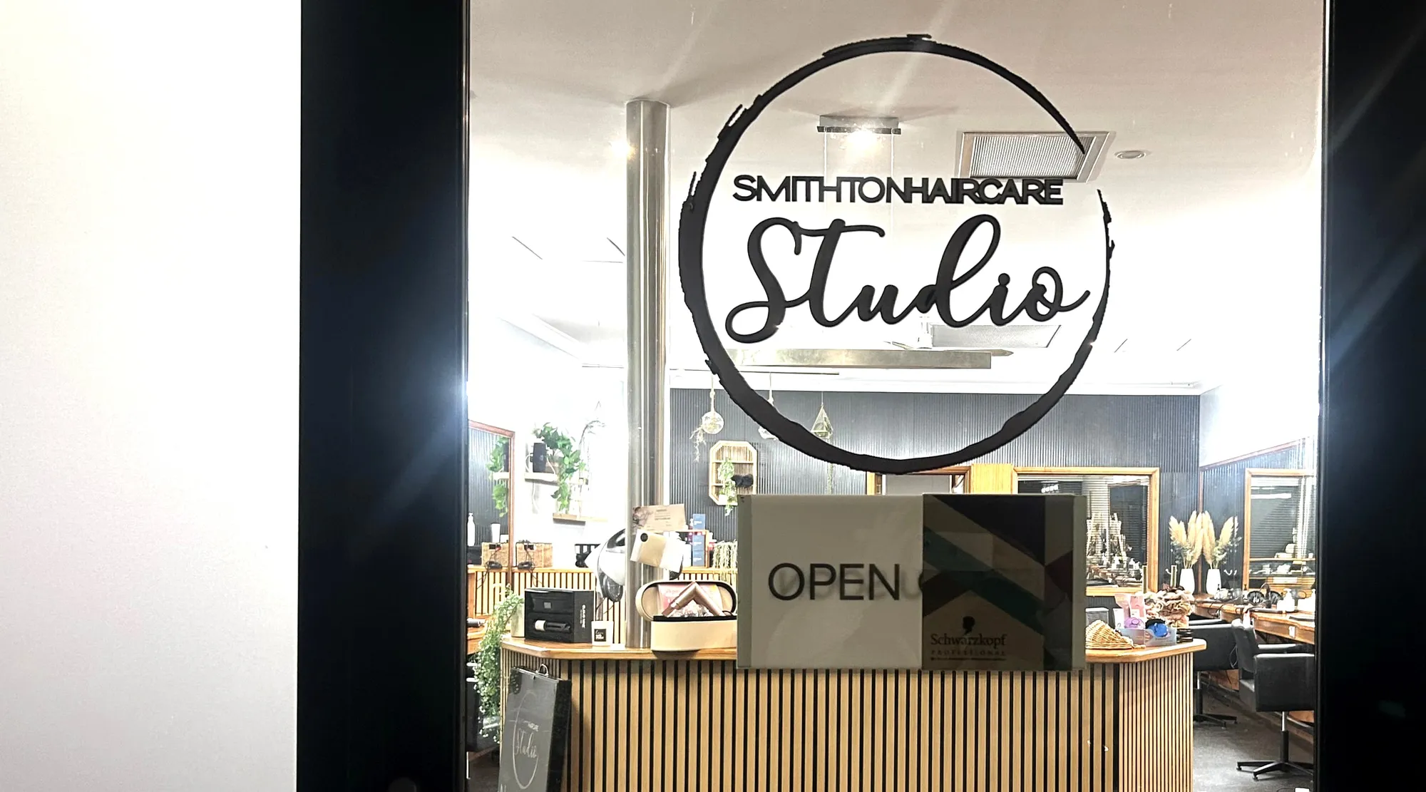 The front door of Smithton Haircare Studio on Nelson Street, looking through to the reception counter and styling floor